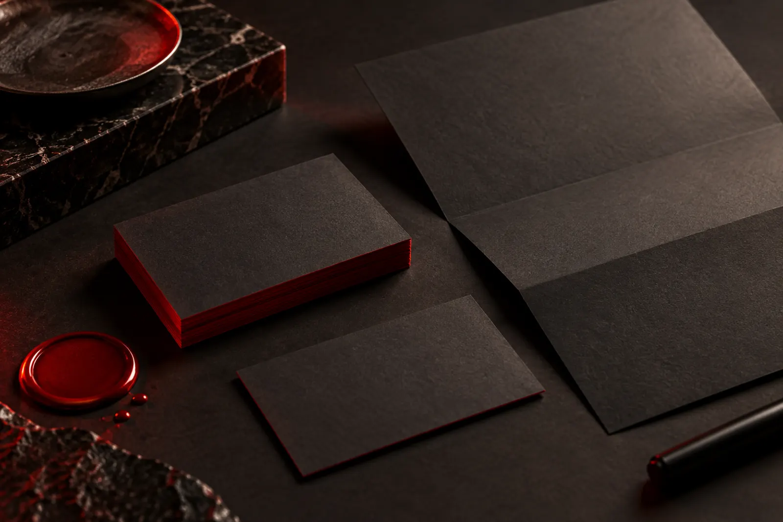 Business cards and letterhead on charcoal paper, illustrating logo and stationery design